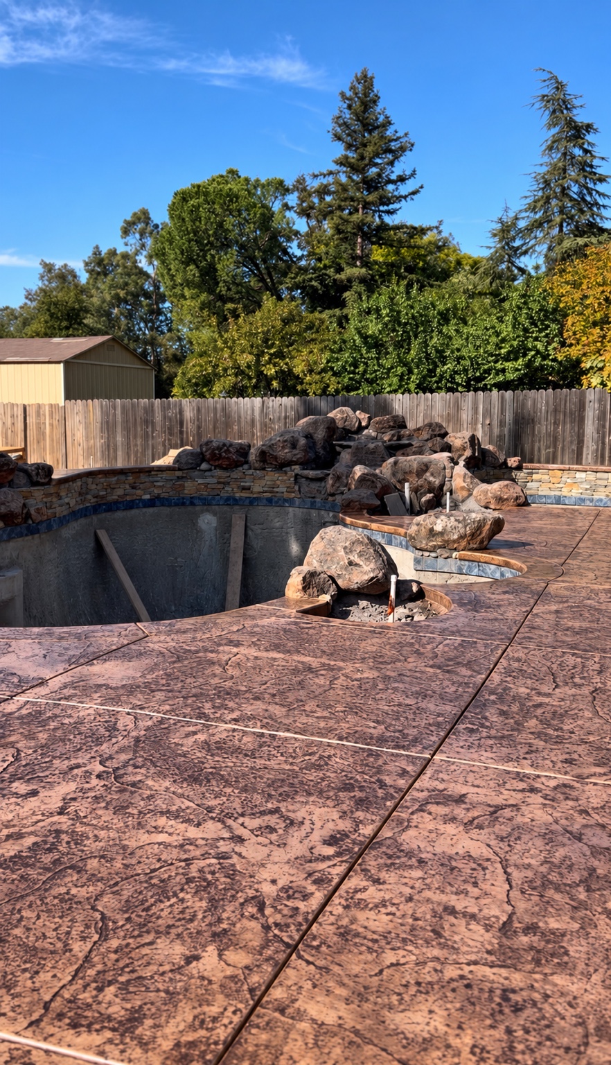 Stamped concrete pool deck with natural rock features